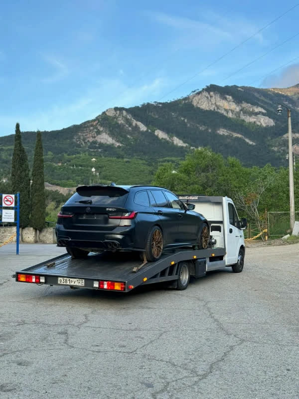 Эвакуатор вытягивает автомобиль из кювета лебедкой
